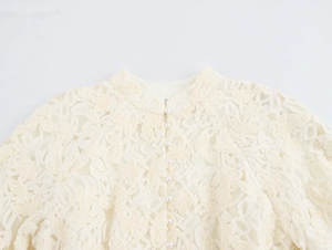 Détail d'une robe en dentelle beige avec boutons de perles élégants et broderie fine