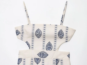 Detail of cream midi dress with blue floral print and side waist cutout design