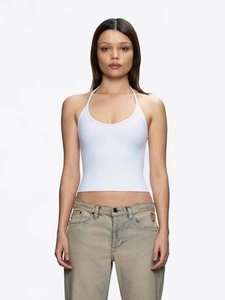 Sleeveless white halter top with backless design paired with light blue jeans