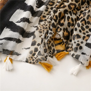 Detail of zebra and leopard print scarf fabric with soft fringes and breathable texture