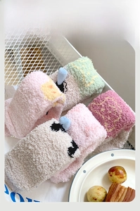 Détails de chaussettes d'hiver en polaire corail avec broderie cartoon dans un panier