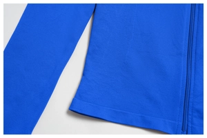 Detail of royal blue zip-up yoga jacket showing rib-knit texture and nylon zipper