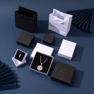 Detail of luxury black and white jewelry gift boxes with gold foil speckles and bags