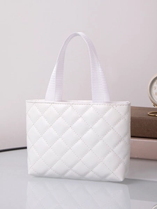 Detailed view of white quilted PU leather tote bag with sturdy handles on a desk