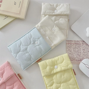 Flat lay of colorful quilted cotton sanitary pad storage pouches in five soft pastel colors