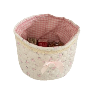 Floral quilted storage basket with lace trim and pink bow for desktop organization