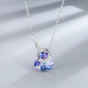 Detail of silver heart necklace featuring gradient crystal and zircon feather charm