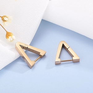 Detailed view of geometric rose gold triangle hoop earrings on a soft aesthetic background