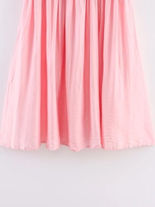 Detailed view of the pleated pink chiffon hemline with fine vertical fold craftsmanship