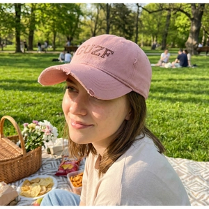 Detail of pink washed vintage baseball cap with GUZF embroidery and distressed edges