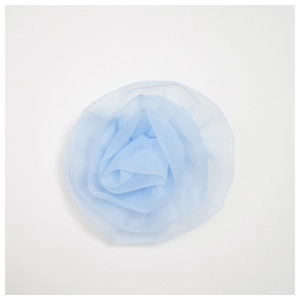 Detail of the light blue mesh rose brooch featuring layered translucent fabric petals
