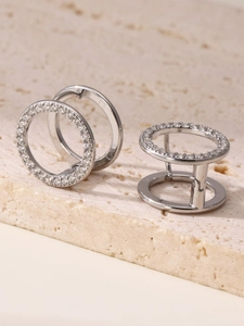 Detalle macro de pendientes plateados PVD con circonitas cúbicas en pavé paralelo