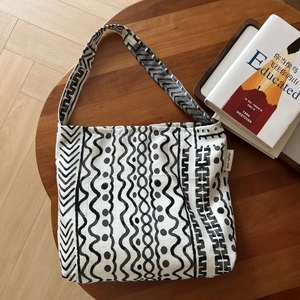 Detail of ethnic geometric print on linen tote bag with brand label on wooden desk