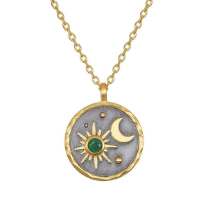 Macro detail of sun and moon totem circular pendant with green gemstone in gold matte finish