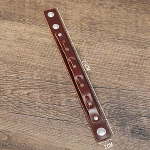 Vintage multilayer dark brown leather bracelet with silver snap button on wood background