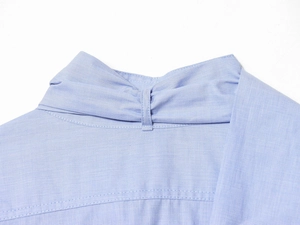 Close-up of light blue shirt collar detail showing fine fabric texture and stitching
