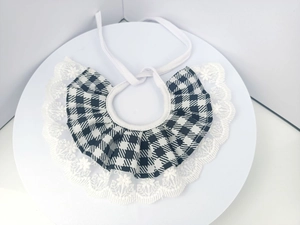 Detail of classic black and white plaid dog bib with delicate lace trim and white ties