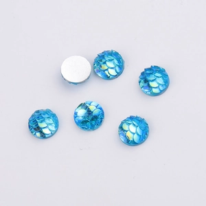 Detail of 8mm blue fish scale resin cabochons showing textured front and flat white back