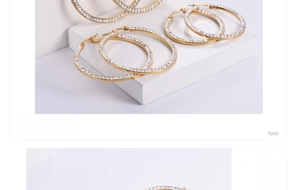 Macro shot of gold-plated titanium hoop earrings with pave set crystal details