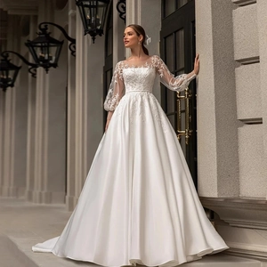Elegant white satin wedding dress with long lace sleeves and ball gown silhouette