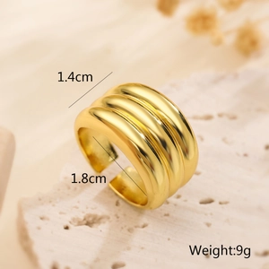 Macro shot of 1.4cm wide gold triple-layered textured ring on a white stone base