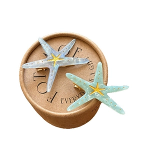 Starfish shaped acrylic hair clips in marbled blue and mint green with gold star accents