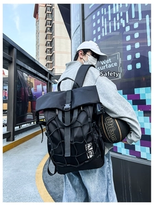 Close-up of black sports backpack with expandable elastic mesh pocket and buckle closure