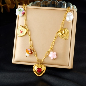 Close-up of a gold-plated necklace with heart, mushroom, and flower ceramic pendants