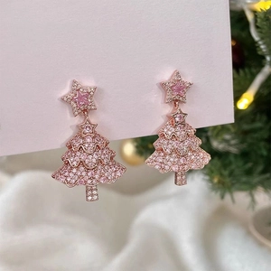 Detailed view of rose gold Christmas tree earrings with pink star gems and small crystals