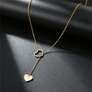 Elegant gold titanium steel Y-necklace with solid and hollow heart pendants on black surface
