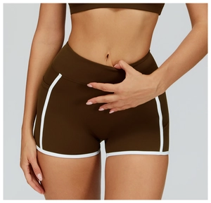 Detail of high-waisted brown yoga shorts with white piping showing fabric stretch