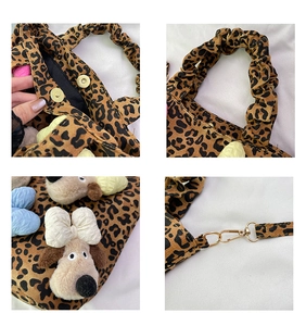 Detail view of leopard print canvas bag with magnetic buckle and cute plush dog charm