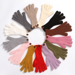 Detailed overhead view of knitted winter gloves in a variety of vibrant fashion colors