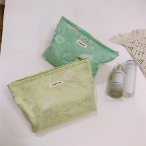 Detail of floral jacquard texture on green and yellow canvas cosmetic bags with zipper