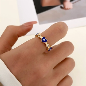 Detail of evil eye heart ring in 14k gold finish with blue enamel and cubic zirconia