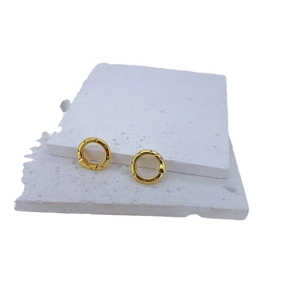 Golden round earrings with zircon pavé setting on white textured stones