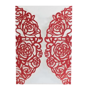 Macro view of laser-cut rose patterns on glittery red paper wedding invitation cover