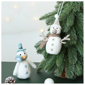 Gros plan d'ornements de bonhomme de neige en laine feutrée sur un sapin de Noël