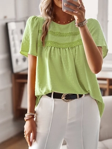 Detail of green short sleeve blouse featuring delicate lace trim and subtle polka dot texture