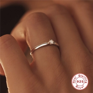 Close-up of six-prong 925 sterling silver ring with sparkling clear zircon on finger