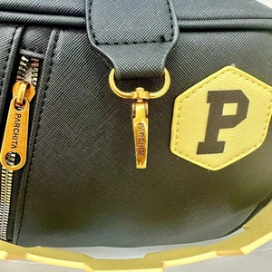 Close-up of black crosshatch leather bag with golden hardware and letter P patch detail