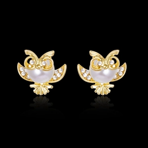 Elegant owl stud earrings in gold with pearls and white rhinestones on black background
