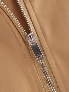 Detail of silver metal zipper on khaki outdoor bomber jacket with twill fabric texture