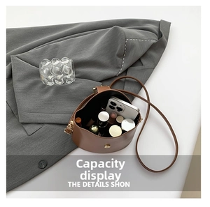 Top view of brown leather bucket bag showing large interior storage for makeup and phone
