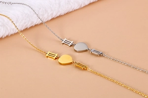 Detailed view of heart pendants on gold and silver necklaces with striped metal bars
