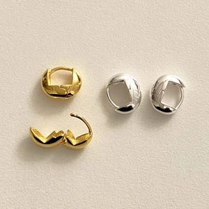 Close-up of minimalist gold and silver hoop earrings with polished finish and snap closure