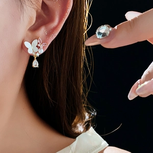 Vue détaillée des boucles d'oreilles papillon avec cristaux roses et zircone goutte