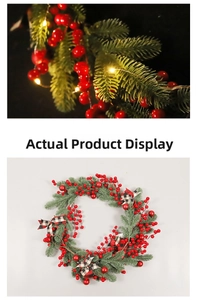 Detail of Christmas wreath with red berries, pine needles, plaid bow and warm LED lights