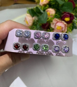 Macro shot of silver-toned square halo earrings with colorful cubic zirconia stones