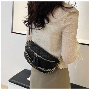 Detail of black quilted leather fanny pack with gold chain straps shown from behind
